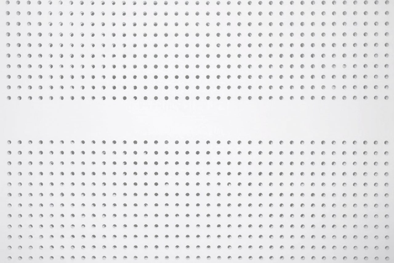 A white perforated metal panel with evenly spaced round holes arranged in horizontal rows, creating a uniform geometric pattern across the surface.