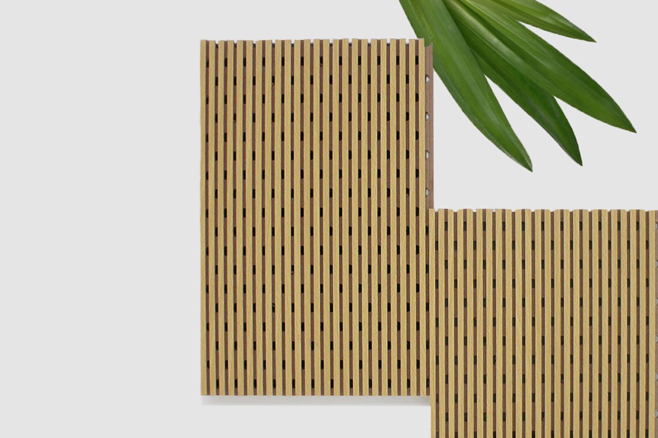 Two rectangular wooden panels with evenly spaced vertical slats overlap at the bottom right. Green leaves extend from the top right corner on a plain, light background.