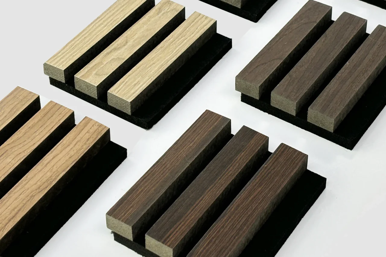 Rectangular wooden blocks in different shades arranged in rows on black bases, displayed on a white background. The blocks form a grid pattern and showcase varying wood textures and colors.