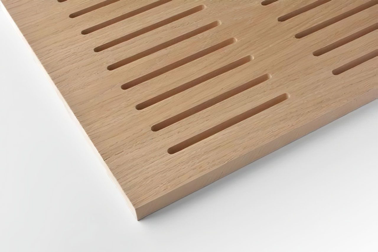 A close-up of a light wooden panel with evenly spaced, parallel rectangular slots cut into the surface, shown on a white background.